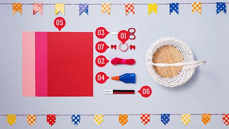 Materiais para correio elegante de festa junina, como papéis coloridos, tesoura, cola, caneta e cestinha