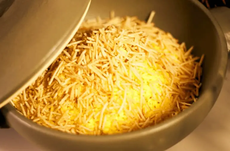 Tigela de arroz cremoso com leite de coco, coberto com batata palha