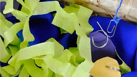 Cesta de pescaria em festa junina, com papéis coloridos, peixinhos com argola e uma vara de pescar com barbante e clipe