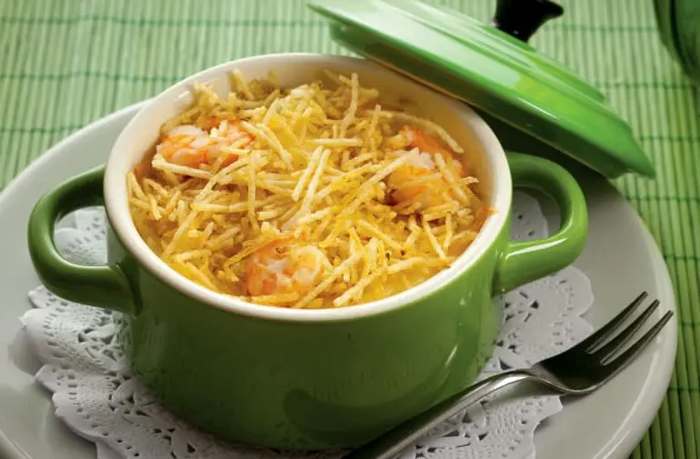 Porção de camarão internacional Coco Bambu com batata palha servido em uma panelinha verde