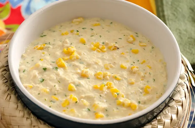Bowl de creme de milho com frango desfiado, servido dentro de um chapéu de palha típico de festa junina