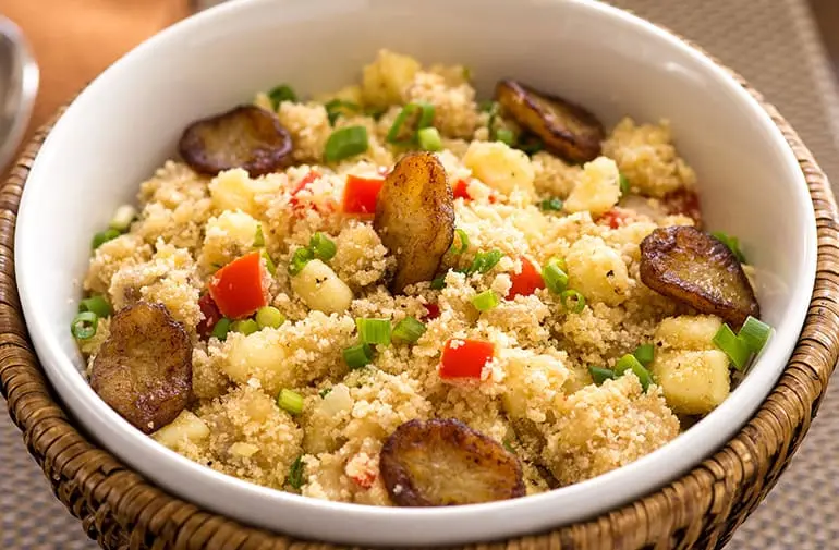 Farofa de banana-da-terra com queijo coalho grelhado e temperos frescos, em tigela rústica de fibras