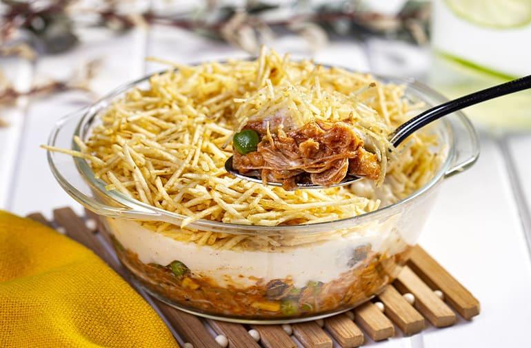 Fricassê vegano com batata palha crocante, feito com carne de jaca, servido em travessa de vidro