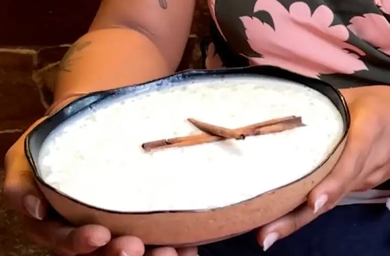 Mingau cremoso de tapioca decorado com canela em pau em travessa rústica, receita de festa junina.