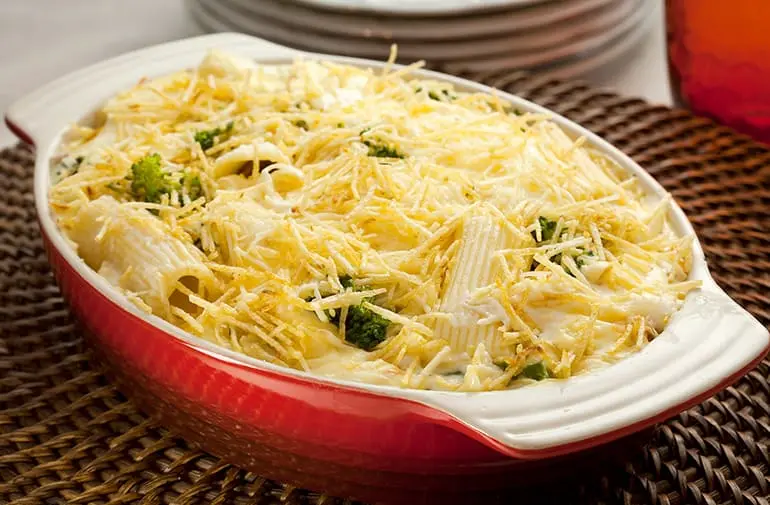 Travessa com macarrão rigatoni gratinado com frango, brócolis, creme branco e batata palha