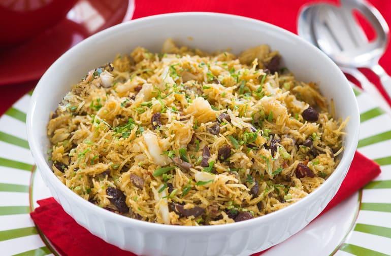 Salada de bacalhau com batata palha crocante servida em uma pequena travessa refratária redonda