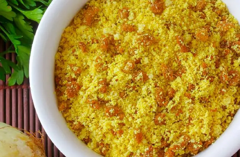 Salada de farofa de cenoura em tigela de porcelana, com cebola, azeitona, limão e salsinha