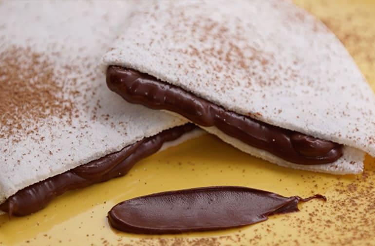 Tapioca recheada com brigadeiro fit cremoso e polvilhada com cacau em pó