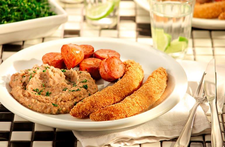 Prato de virado à paulista com tutu de feijão, linguiça frita e banana empanada, com acompanhamento de couve