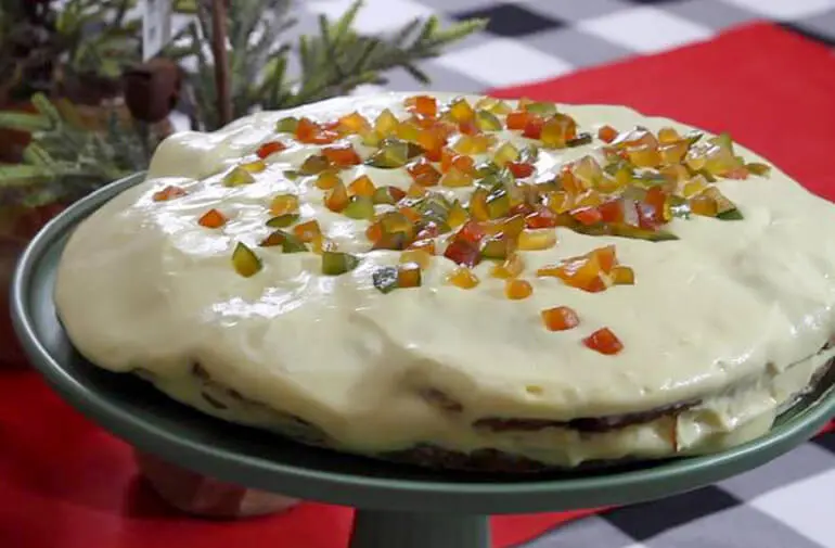 Torta gelada de panetone recheada com doce de leite, cobertura de sorvete de creme e decorada com frutas cristalizadas
