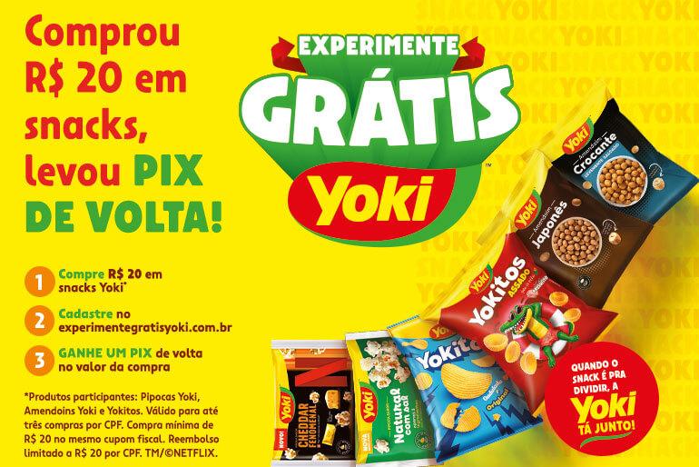 Banner promocional da Yoki com a oferta 'Comprou R$ 20 em snacks, levou PIX de volta!'. Instruções: 1. Compre R$ 20 em snacks Yoki; 2. Cadastre no experimentegratisyoki.com.br; 3. Ganhe um PIX de volta no valor da compra. Imagem de diversos produtos Yoki, incluindo pipocas, amendoins e salgadinhos. Texto adicional: 'Quando o snack é pra dividir, a Yoki tá junto!'.
